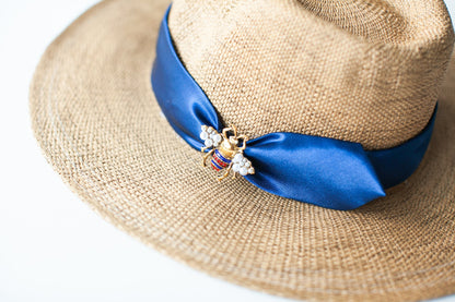 Close-up of blue silk ribbon and bee decoration