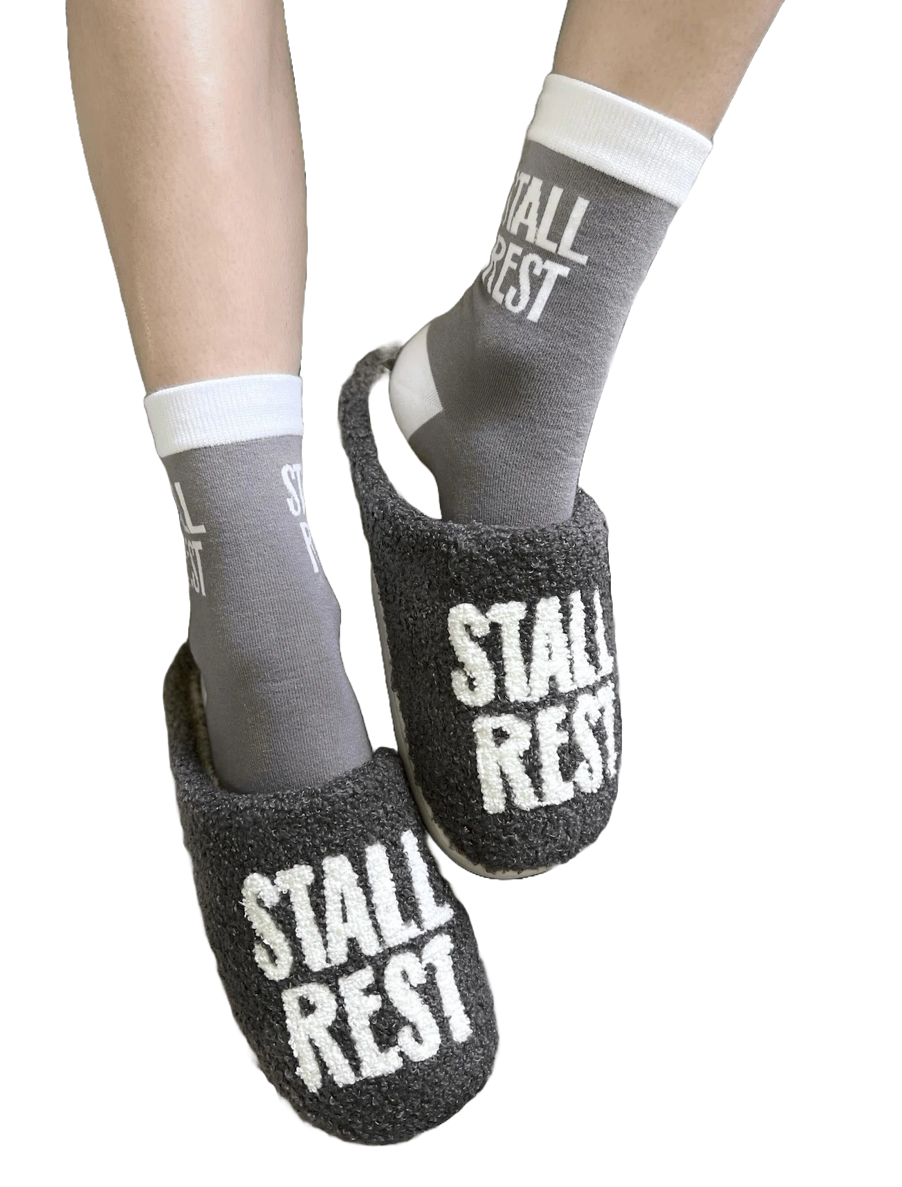 Model wearing Stall Rest slippers in grey