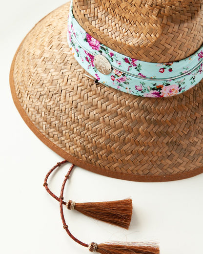 Close-up of hat with patterned band, logo medallion and horsehair tassels