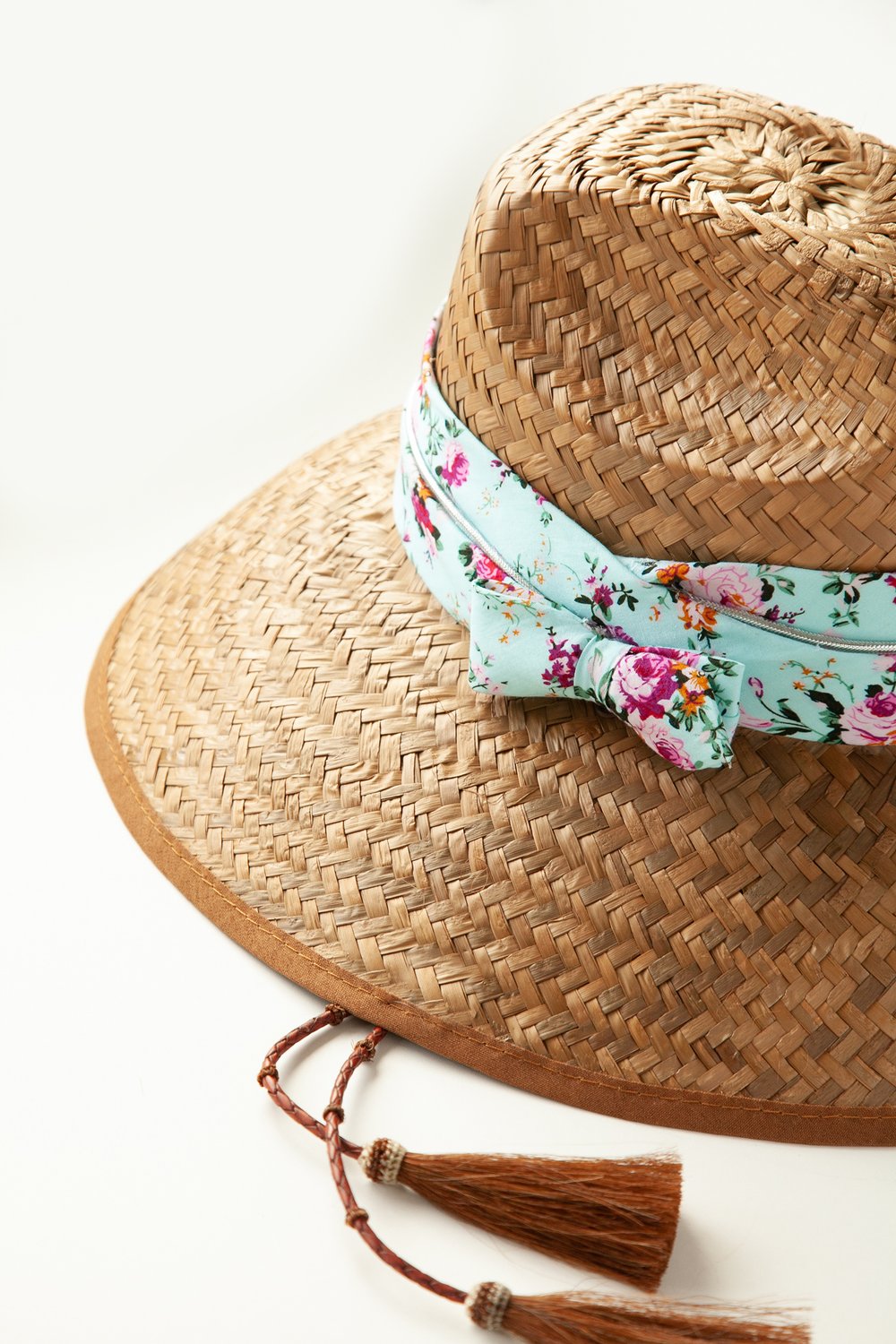 Side view of woven hat with bow and horsehair tassels