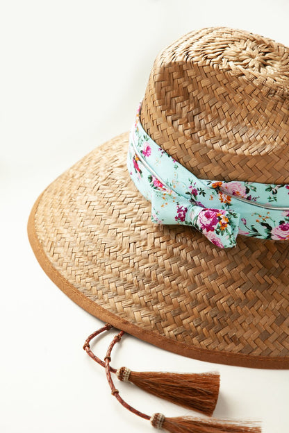 Side view of woven hat with bow and horsehair tassels